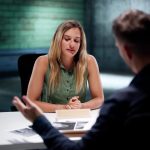 Woman being questioned by a detective in a police interview room — Georgia criminal defense lawyers explain whether to talk to police if you didn't do anything wrong.