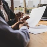 Defense lawyer reviewing a document with a client at a conference table